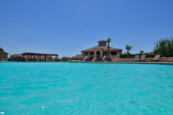 Sparkling pool with stylish lounge chairs and a shaded pavilion for relaxation; perfect for unwinding after duty | Dream TDY