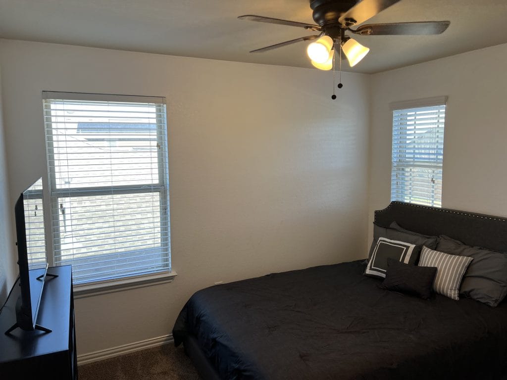 Cozy bedroom featuring a comfortable bed, sleek dresser, and a TV. Abundant natural light and clean decor for a relaxing stay | Dream TDY