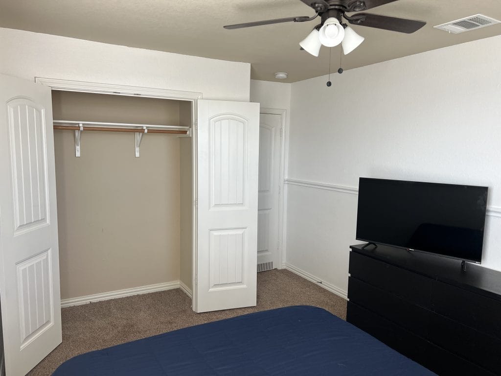 Cozy bedroom featuring a TV, ample closet space, and a clean aesthetic for a comfortable stay | Dream TDY