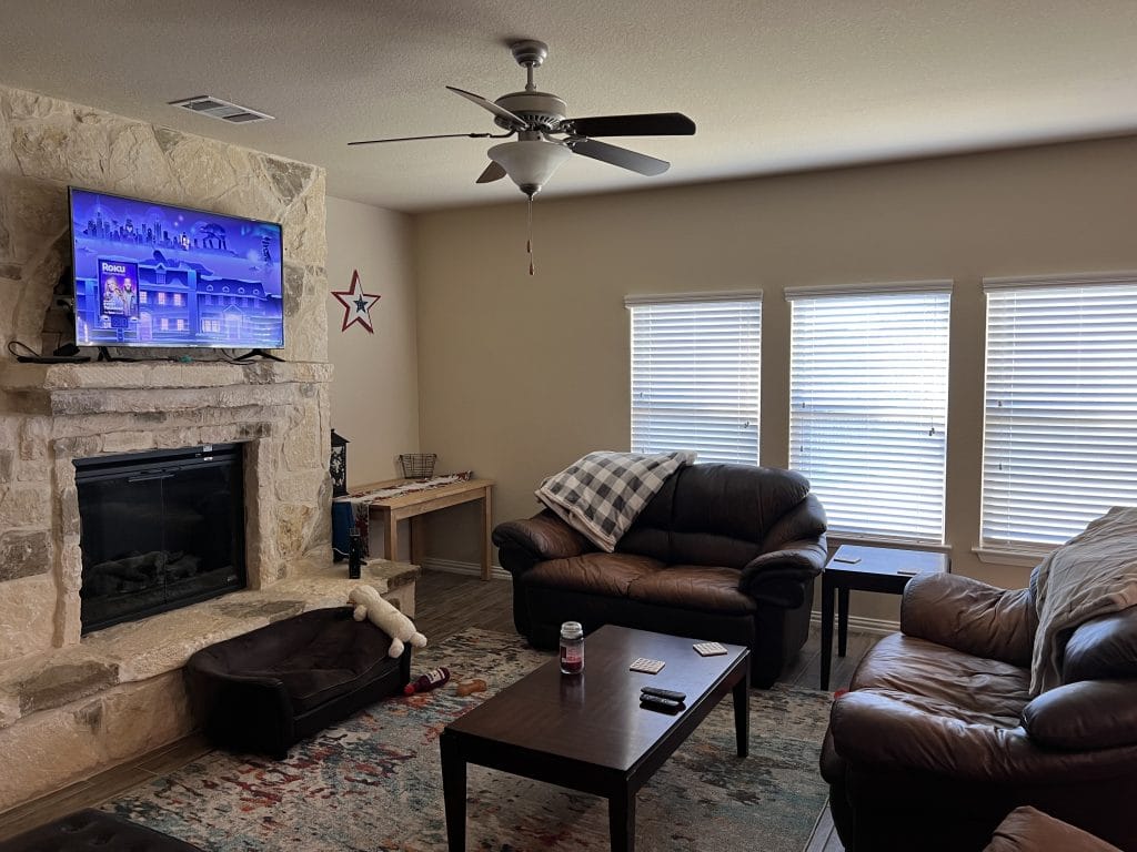 Cozy living room featuring leather sofas, a stone fireplace, and ample natural light. Perfect for relaxation and unwinding | Dream TDY